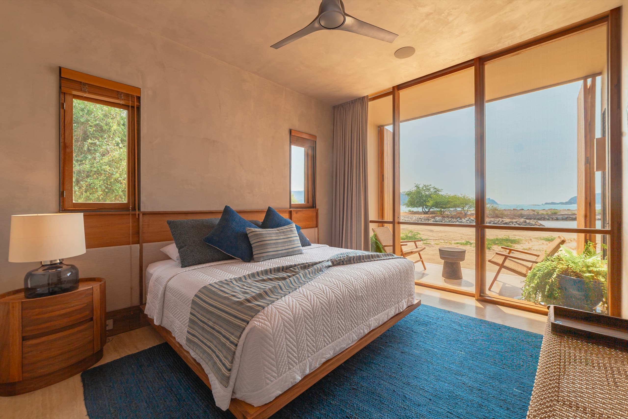 Suite con vista al mar, cama king y ventanales de piso a techo
