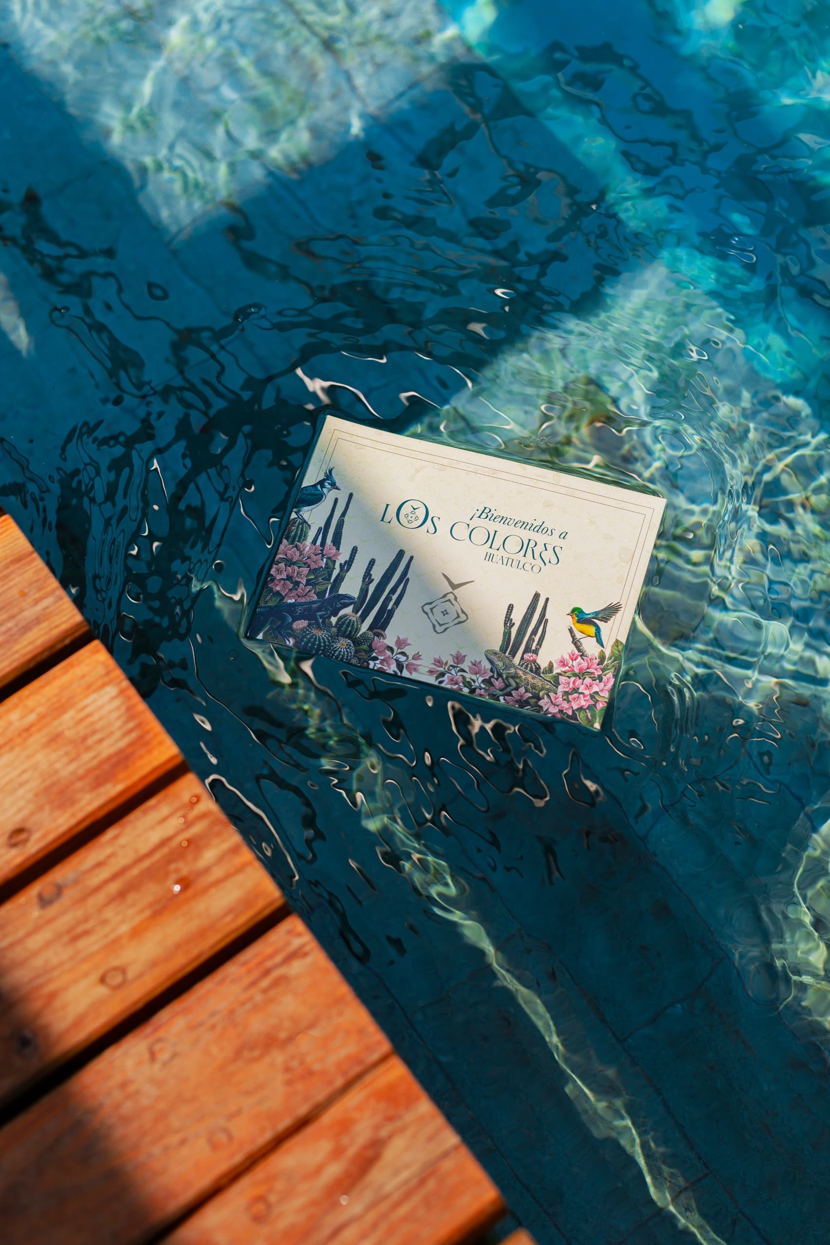 Tarjeta de bienvenida de Los Colores flotando en la piscina